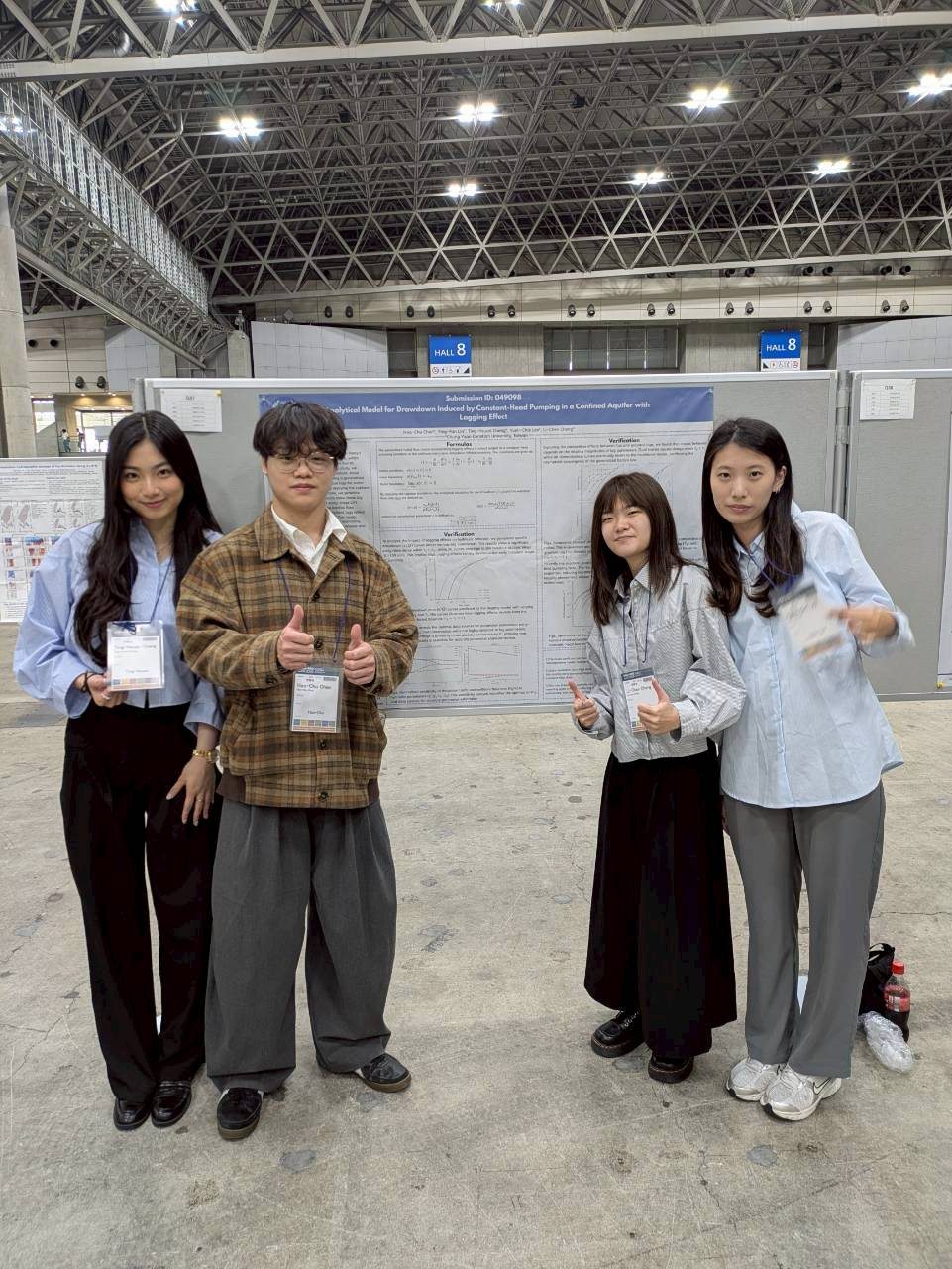 Research group standing in front of a JpGU 2026 conference poster.